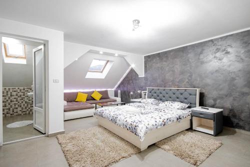 a bedroom with a bed and a couch in it at Cazare MOLDI - regim hotelier in Câmpulung Moldovenesc