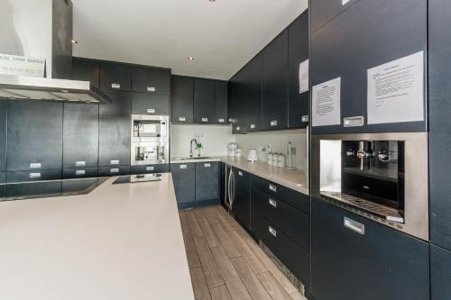 a kitchen with black cabinets and a white counter top at Ocean View,Kinsale, Hosted by Exquisite holiday homes, sleeps 22 in Kinsale