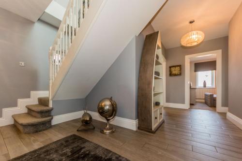 a living room with stairs and a stair case at Ocean View,Kinsale, Hosted by Exquisite holiday homes, sleeps 22 in Kinsale