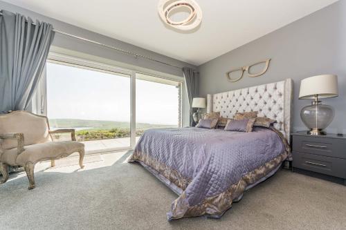 a bedroom with a bed and a large window at Ocean View,Kinsale, Hosted by Exquisite holiday homes, sleeps 22 in Kinsale
