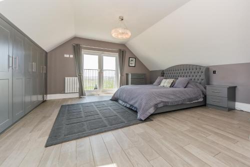 a bedroom with a bed and a large window at Ocean View,Kinsale, Hosted by Exquisite holiday homes, sleeps 22 in Kinsale