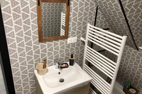 een badkamer met een witte wastafel en een spiegel bij Gite PIPIOU ETAPLES 2 à 4 Personnes in Étaples