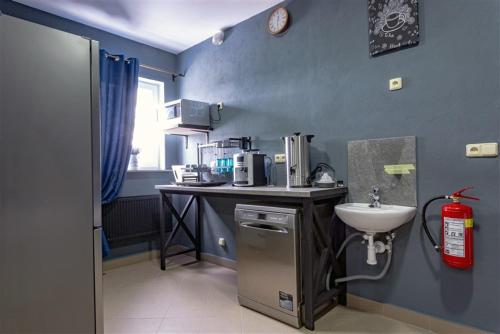 a small kitchen with a sink and a counter at Hostel IRON CUBE in Stružná