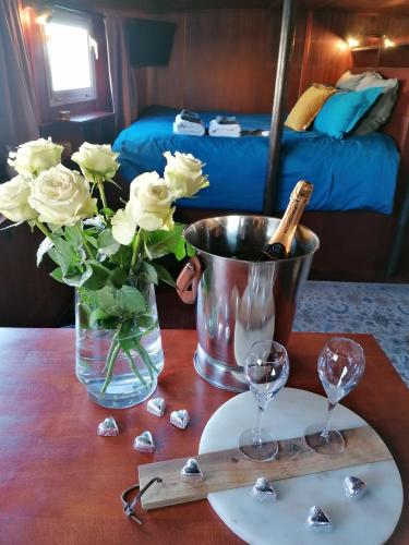 a table with a vase of flowers and wine glasses at La Cabine du Capitaine in Liège