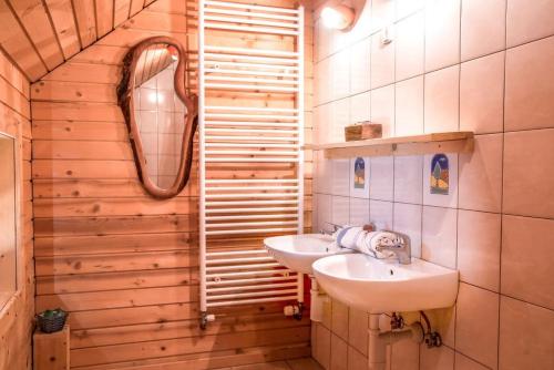 a bathroom with two sinks and a mirror at Ranch Kaja & Grom in Vojnik