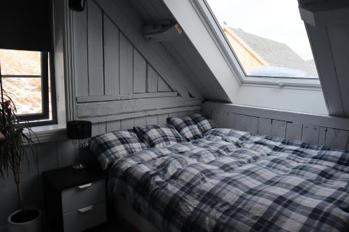 a bed sitting in a room with a window at Dyr tillatt i vakkert hus med naturomgivelser i Lofoten in Sennesvik