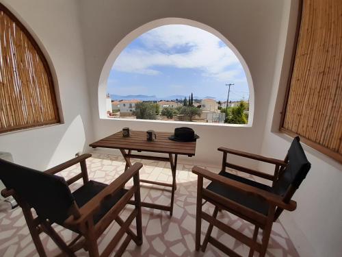 Habitación con mesa, 2 sillas y ventana en SORINA Beloved Rooms en Spetses