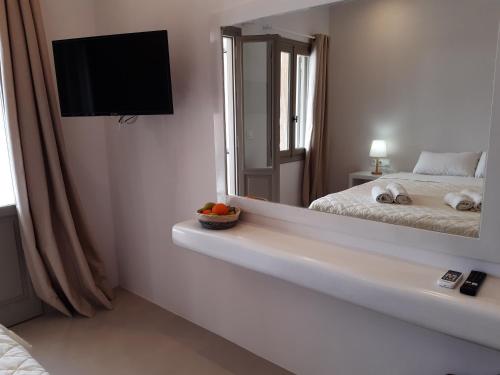 a bedroom with a mirror and a bed and a television at SORINA Beloved Rooms in Spetses