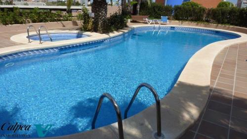 ein großer Pool mit blauem Wasser in der Unterkunft Oasis 1A Playa Arenal Calpe in Calpe