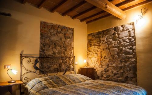 a bedroom with a bed in a stone wall at Bioagriturismo Poderaccio in Incisa in Valdarno