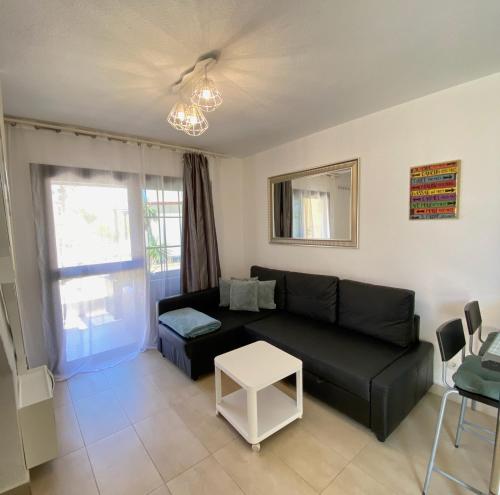 a living room with a black couch and a table at Casa Hugo in Costa Calma