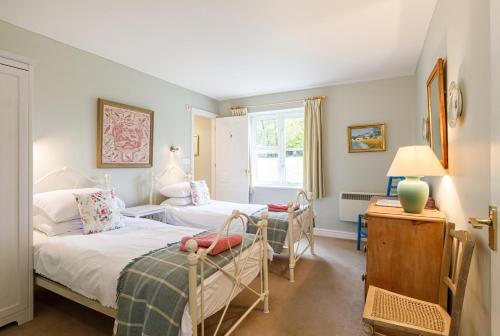 1 dormitorio con 2 camas y ventana en Stable Cottage - Milton Lilbourne, en Pewsey