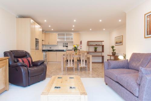 a living room with a couch and a table at Camstay Longworth Avenue in Cambridge