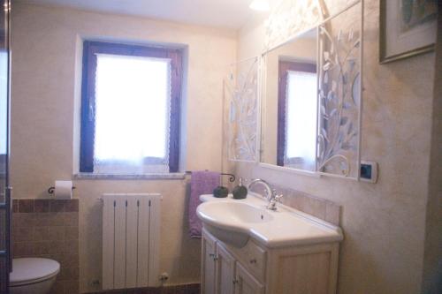 a bathroom with a sink and a toilet and a mirror at La Casa Del Viandante in Radicofani