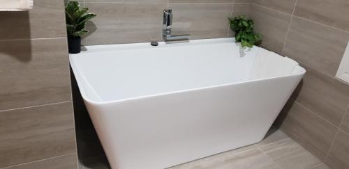 a white bath tub in a bathroom with a sink at Oxford Rise Apartment in Bayswater