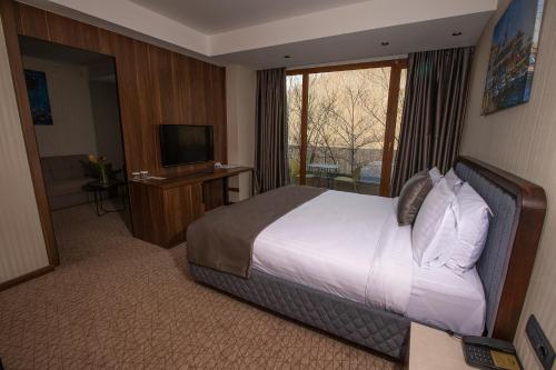 a hotel room with a bed and a television at Brezovica Hotel & SPA in Brezovicë
