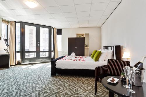 um quarto de hotel com uma cama e uma mesa em Hotel De Schout em Denekamp