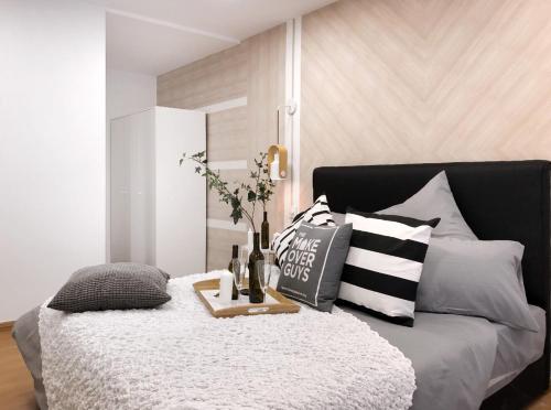 - une chambre avec un lit noir et blanc et des oreillers dans l'établissement MLH Designer Duplex Suite @ EkoCheras, à Cheras