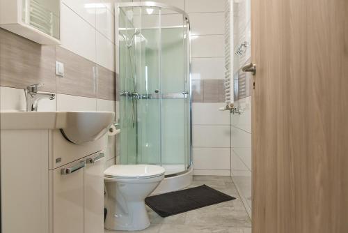 a bathroom with a toilet and a glass shower at Dom Wycieczkowy "Na stadionie" in Kłodzko
