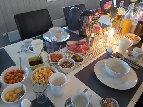 a table with plates and bowls of food on it at Varangertunet Aldonen Apartment in Vadsø