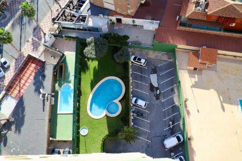 an overhead view of a yard with cars and a pool at Apartamentos Torre Gerona in Benidorm