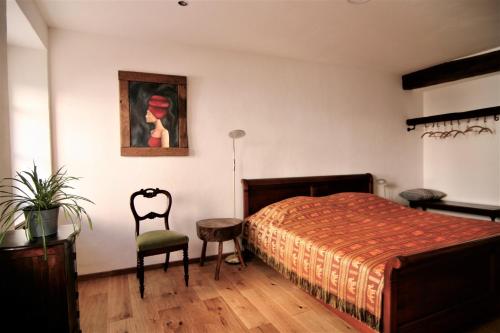 1 dormitorio con 1 cama y una pintura en la pared en Altstadt Blieskastel - Kardinal-Wendel-Straße 18, en Blieskastel