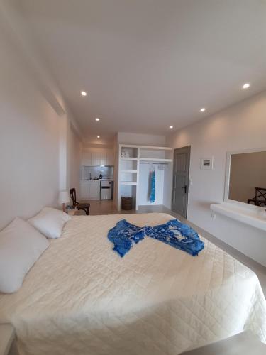 a bedroom with a large bed with a blue blanket on it at SORINA Beloved Rooms in Spetses