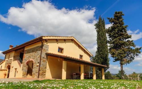 a house in a field with a tree at Bioagriturismo Poderaccio in Incisa in Valdarno