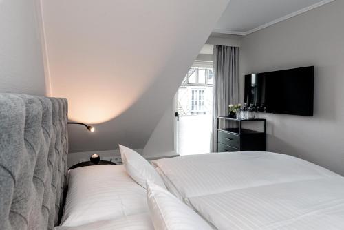 a bedroom with a bed and a flat screen tv at Jaumann's Südwind Sylt in Westerland (Sylt)