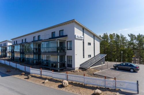 a building with a car parked in a parking lot at Seastar 101 in Kalajoki