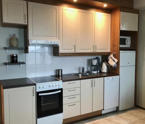 a kitchen with white appliances and white cabinets at Seastar 101 in Kalajoki