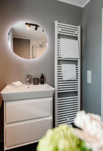 a bathroom with a sink and a mirror at Jaumann's Südwind Sylt in Westerland (Sylt)
