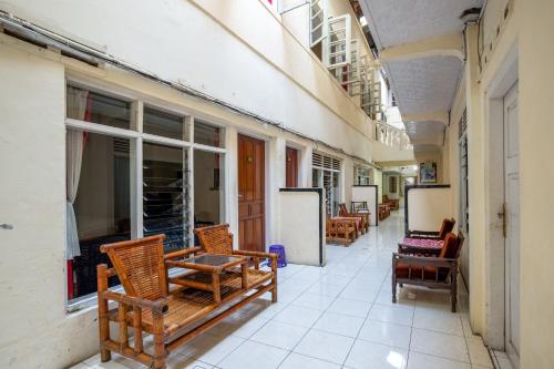 a hallway with chairs and tables on a building at Hotel Jogja Bukittinggi in Bukittinggi