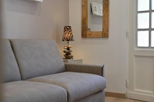 a chair in a room with a lamp and a mirror at L'Arche de Porquerolles in Porquerolles