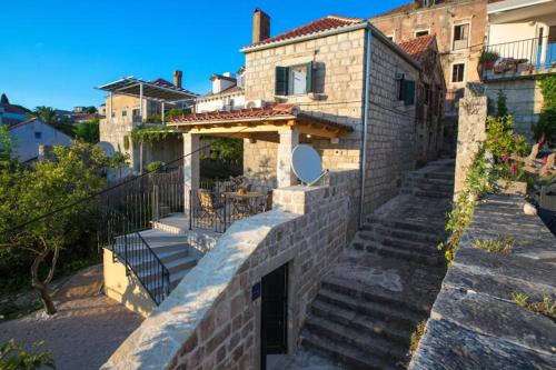 a brick house with stairs leading up to it at Sweet Old Stone House Cavtat in Cavtat