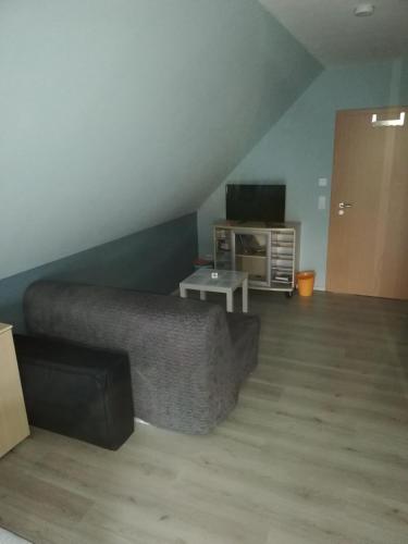 a living room with a couch and a tv at Gästehaus Querenhorst in Querenhorst