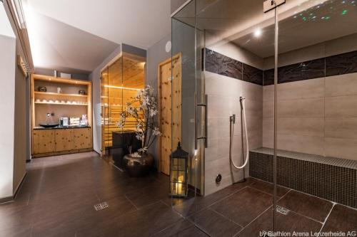 a bathroom with a shower and a glass shower stall at La Tgoma - Hotel & Restaurant in Lenz