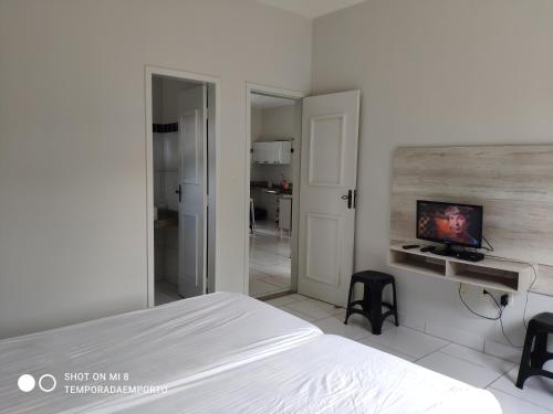 1 dormitorio con 1 cama y TV en la pared en Apartamento Completo Porto Di Nassau, en Porto Seguro