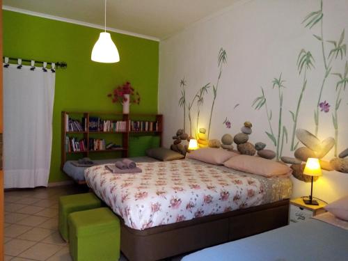 a bedroom with green walls and a bed and a book shelf at Il Nido della Quaglia in Pozzuoli