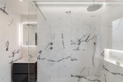 a white bathroom with a shower and a sink at Howe Top in Bowness-on-Windermere