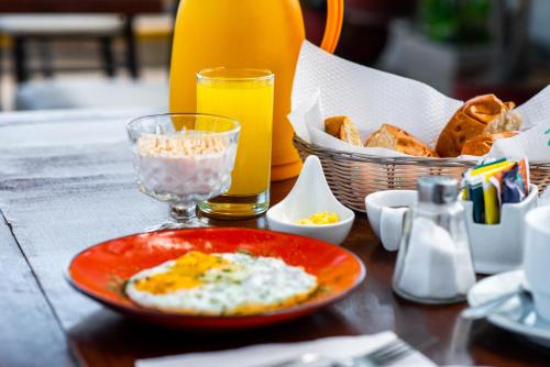 a table with a plate of food and a glass of orange juice at Le Foyer Arequipa in Arequipa