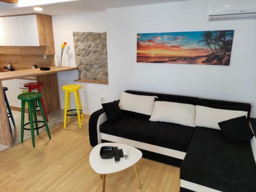 ein Wohnzimmer mit einem schwarzen Sofa und einem Tisch in der Unterkunft DAN in Rijeka