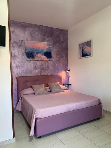 ein Schlafzimmer mit einem lila Bett in einem Zimmer in der Unterkunft Monolocale Viola - A casa di Ludovica e Martina in Gallipoli