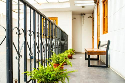 a porch with a bench and potted plants at Le Foyer Arequipa in Arequipa