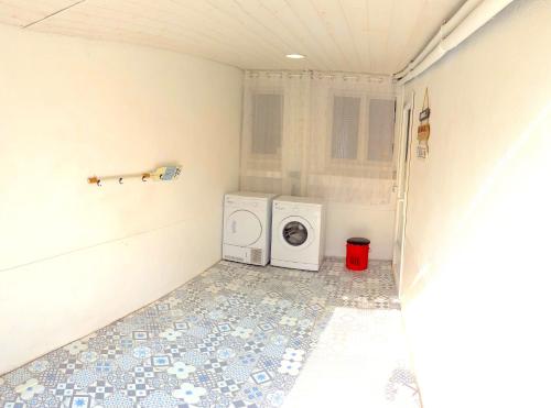 a laundry room with a washer and a washing machine at Maison à 30m de la plage avec grand jardin in Plérin