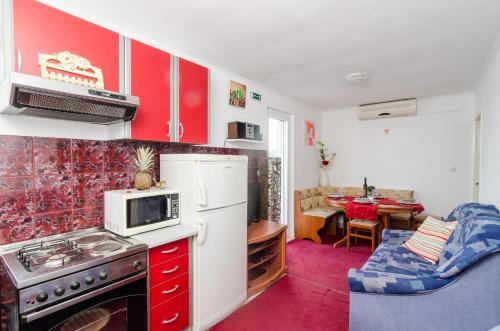 a kitchen with red cabinets and a white refrigerator at Apartment Giovani in Slano
