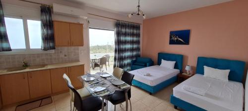 a hotel room with a table and a bed and a kitchen at Sunset Bella Vista in Athanion