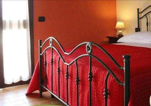 a bedroom with a red bed with a red blanket at B&B Il Casolare in Sant'Isidoro