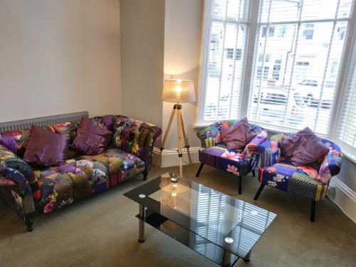a living room with two couches and a table at The Castleton in Blackpool