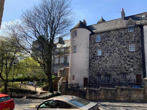 a car parked in front of a stone building at Old Spittal Hospital Apartment - Free Parking in Stirling